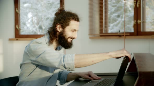 a Man Hypocritically Says Goodbye to the Team While Working From Home on a Video Call alt