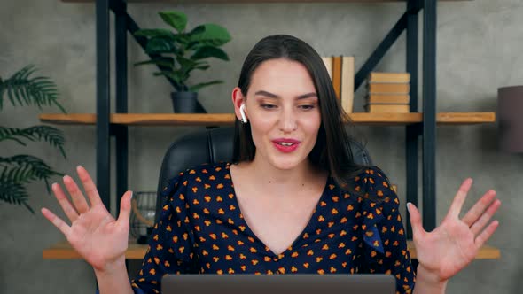 Emotional woman in home office in wireless earphone talk teacher remote video conference call laptop alt