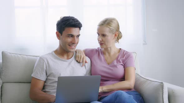 Couple Using Laptop in a Conversation alt