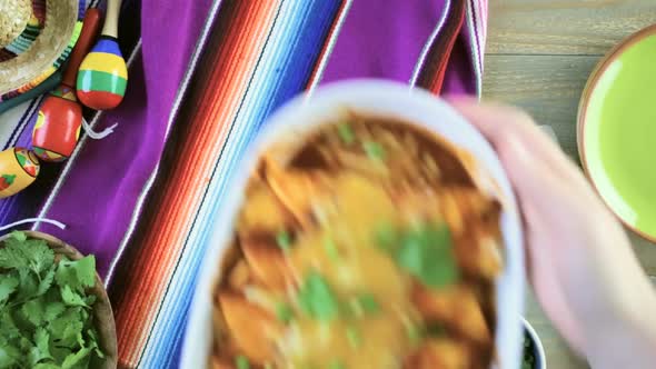 Homemade chicken enchiladas garnished with green onions and cilantro in a white casserole dish. alt