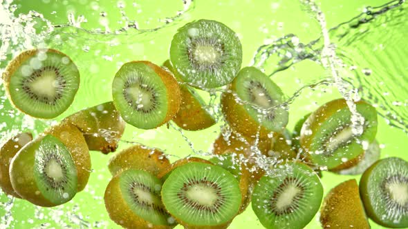 Super Slow Motion Shot of Flying Fresh Kiwi Slices and Water Side Splash at 1000 Fps alt