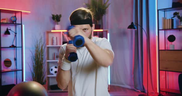 Bearded Guy in Sportswear Doing Boxing Exercises with Dumbbells alt