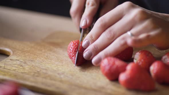 Cook with Golden Ring on Finger Cuts Red Strawberry Closeup
