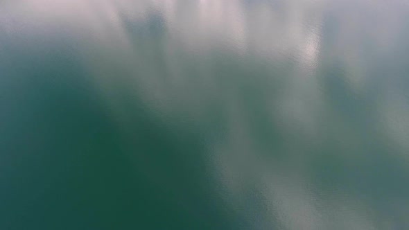 Flying Over Water Surface with Clouds Reflection alt