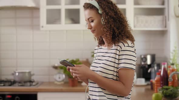 Woman listening to music in the kitchen alt