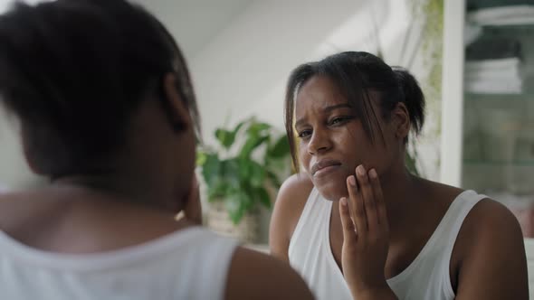 African-American woman  in the bathroom having a strong toothache or bruxism. Shot with RED helium c alt