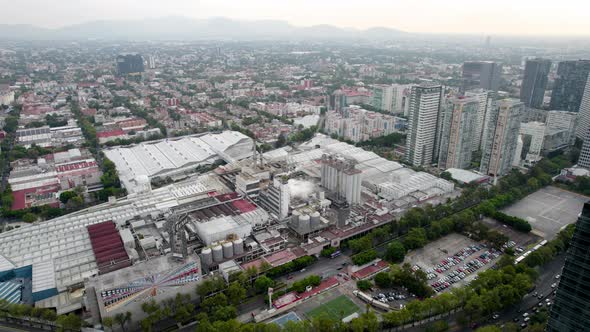 orbital drone shot of a beer factory in the industrial heart of mexico city alt