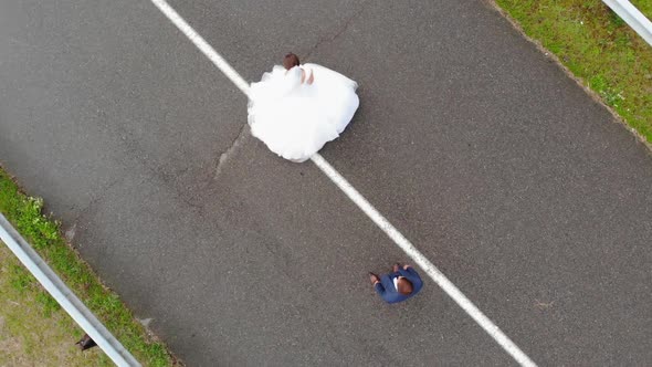 The Newlyweds Dance on the Road on Their Wedding Day alt