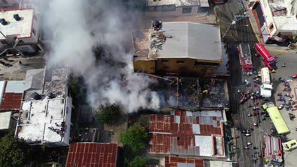 Aerial view above a smoking building, firefighters trying to control the fire, in ghetto Favela, Rio alt