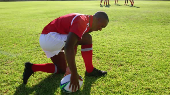 Male rugby player tying shoelaces on the rugby ground 4k