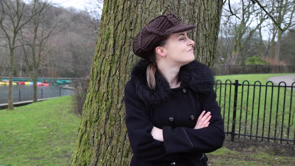 An attractive young woman in a park looking cold and upset while waiting for somebody  alt