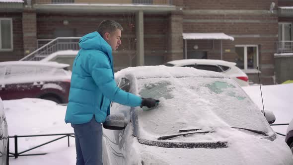 Person Driver Cleans the Car From Snow with a Brush