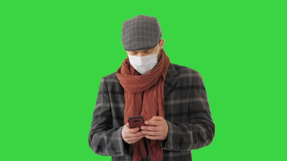 Gentleman in Medical Mask Using Phone and Walking on a Green Screen, Chroma Key alt