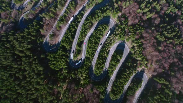 Aerial: top down view of winding mountain hairpin road, Bratocea Pass in Romania alt