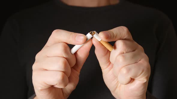 Young Adult Man Holds A Cigarette At Hands And Break It alt