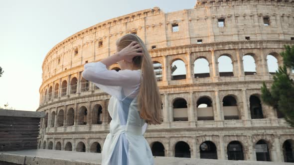 A Girl Makes a Selfie in Rome Near the Colosseum.