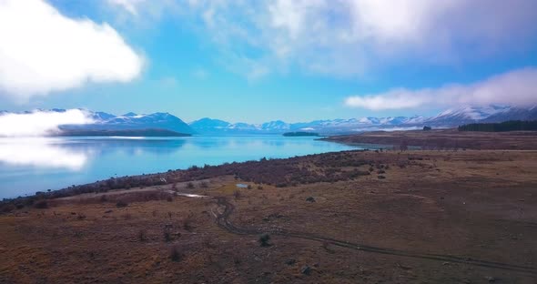 Aerial shot of Calming and relaxing Tekapo Lake in New Zealand. Epic cinematic aerial shot of flying alt