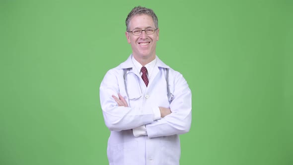 Portrait of Happy Mature Man Doctor Wearing Eyeglasses with Arms Crossed