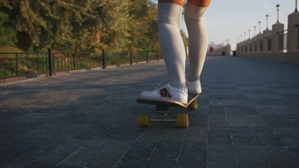 Young Stylish Attractive Woman Skateboarding at Sunrise on Seafront Slow Motion Close Up alt