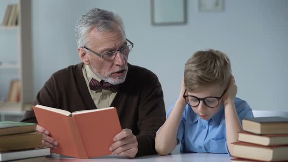 Grandfather Reading Aloud Book, Little Boy Looks Bored, Generation Gap Problem alt