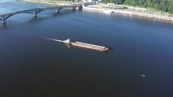 River Barge in Tow Floats Along the Channel of the River  Drone Aerial Orbit Shot alt