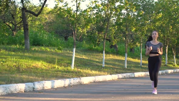 View on Young Woman Are Exercising with Outdoor Running in the City Park