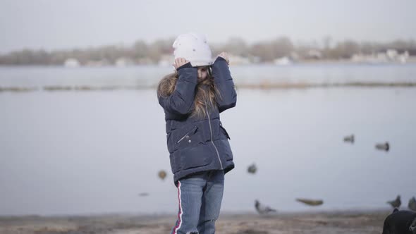 Portrait of Sad Caucasian Little Girl Rubbing Eyes and Leaving with Small Pinscher. Unhappy Child alt