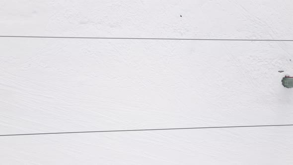 Flying over rope-way with gondolas at mountain resort Crystal Park in Bakuriani. Snowy winter day. alt