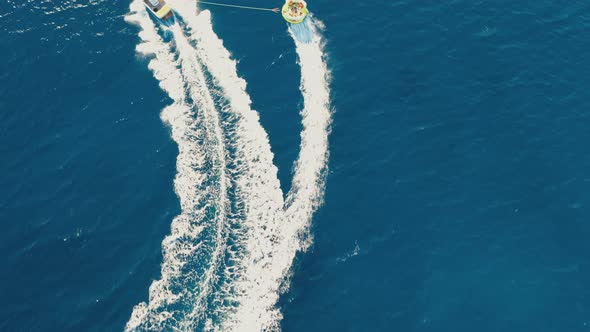 Aerial View of a Motor Boat Towing a Tube. Elounda, Crete, Greece