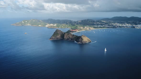 An air drone takes off as a yacht bypasses a mountain on the coast (Rodney Bay, Saint Lucia) alt
