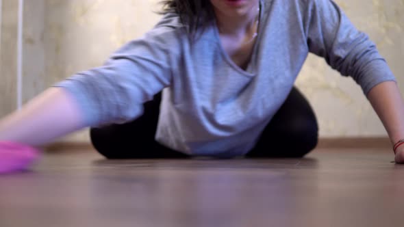 Woman Housewife Cleaning Floor with Pink Rag on the Knees at Home Dust