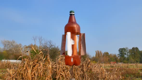 The rotating plastic bottle scares birds in the garden.