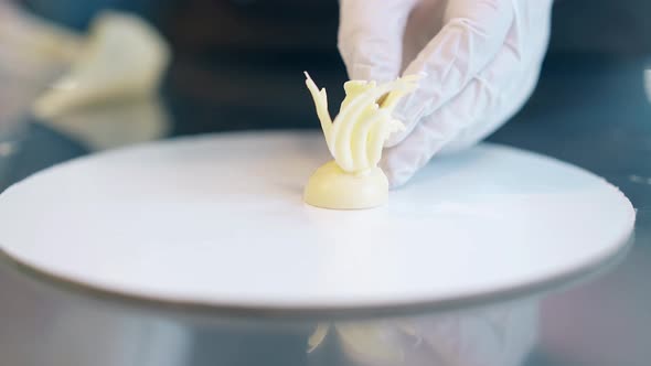 Confectioner Cooks Decorative Element From White Chocolate alt