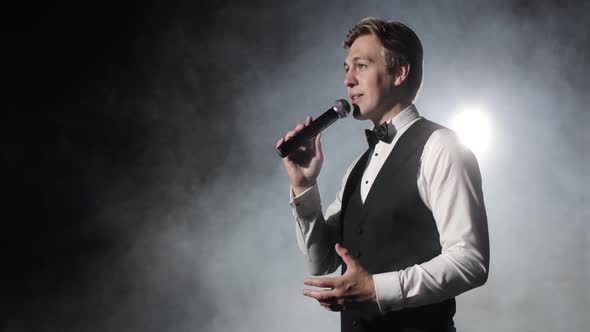 Showman Host of Event Speaks at Microphone Entertains Audience at Concert.