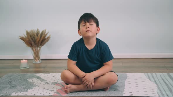 Caucasian Boy Does Yoga Online Child Sits in the Lotus Position and Indulges Yoga for Beginners