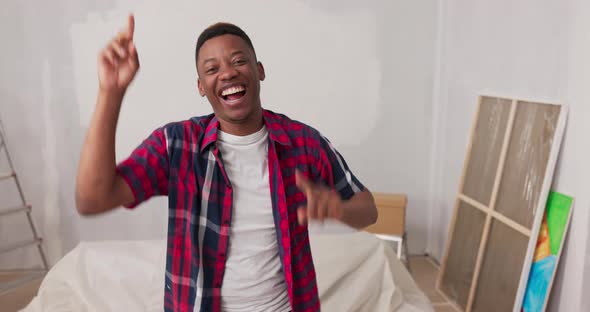 A Man Looks Into the Camera with a Proud Face Smiling in the Background a Wall Painted Freshly alt