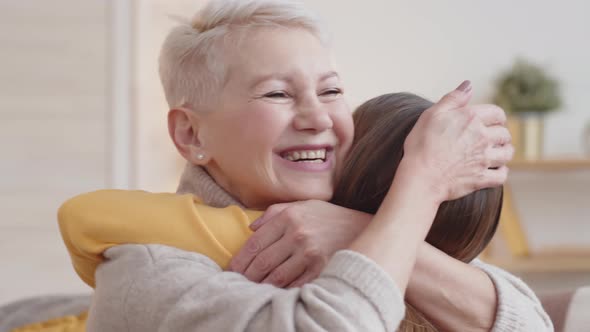 Loving Caucasian Granny Hugging Granddaughter at Home alt