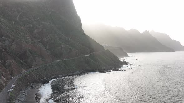 Rocky Volcanic Beach Surrounded By High Mountains and Cliffs Aerial Drone View alt