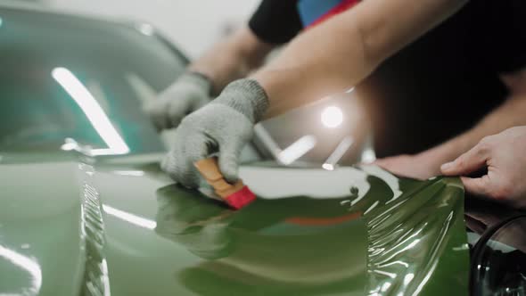 Process of Vinyl Wrapping a Car in Khaki Green Color Using Plastic Cards