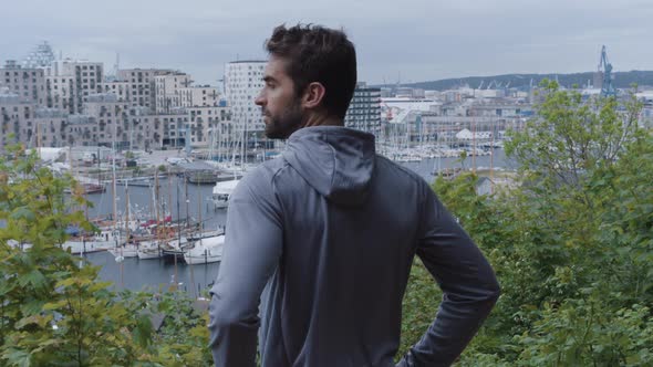 Athlete In Grey Looking Over Trees And Harbour