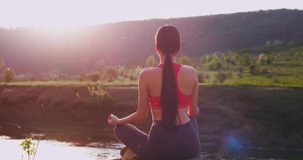 Young Lady Practicing Yoga at Nature in the Middle alt