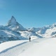 Blue Matterhorn Mountain in Winter Day and Hiker Man. Swiss Alps, Switzerland. Aerial View - VideoHive Item for Sale