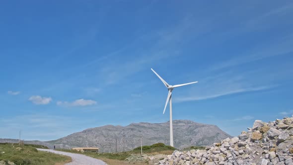 Panning of Wind Turbine Farm in Hill Landscape on Sunny Day