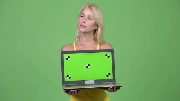 Young Happy Beautiful Blonde Woman Thinking While Showing Laptop