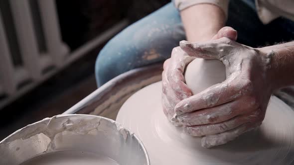 Concentrated Potter Making Vase in Workshop Studio