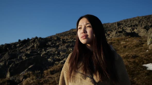 Cute Brunette Asian. Portrait Photography Against the Backdrop of the Mountains
