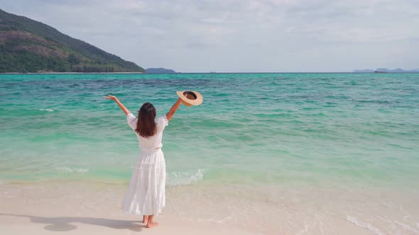 Young woman traveler relaxing and enjoying at beautiful tropical white sand beach