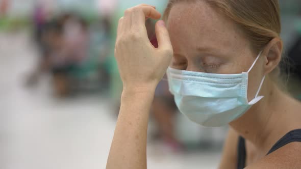 Sick Young Woman Sitting in a Hospital Waiting for Doctor's Appointment alt