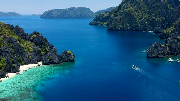 Wide Aerial panof boat passing Shimizu island. El Nido, Palawan, Philippines alt