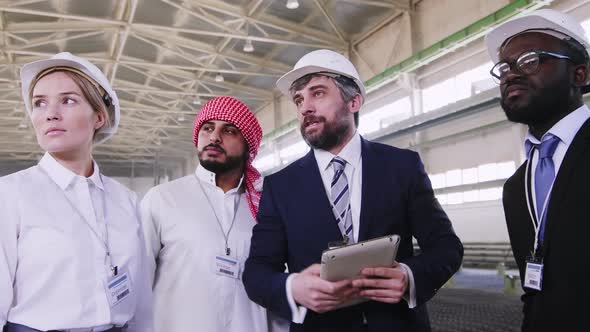 Tour organizer showing factory to multinational guests